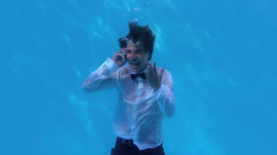 stock-footage-cheering-businessman-underwater-in-pool-talking-on-smartphone-in-slow-motion.jpg